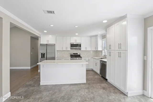 a large kitchen with cabinets and stainless steel appliances