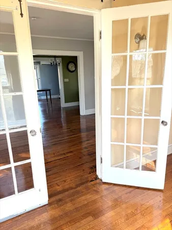 a view of a living room with wooden floor and a large window