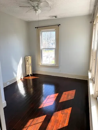 a view of a room with wooden floor and window