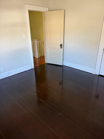 an empty room with wooden floor and entrance