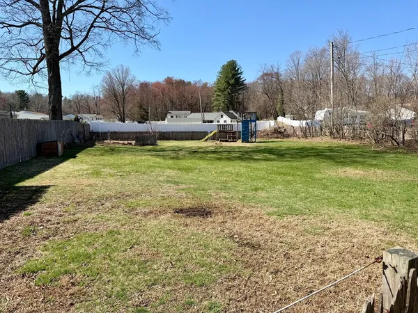 a view of a yard with wooden fence