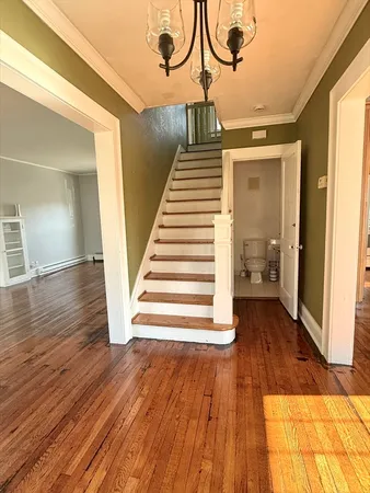 a view of entryway and hall with wooden floor