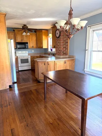 a kitchen with granite countertop wooden floors and a view of living room