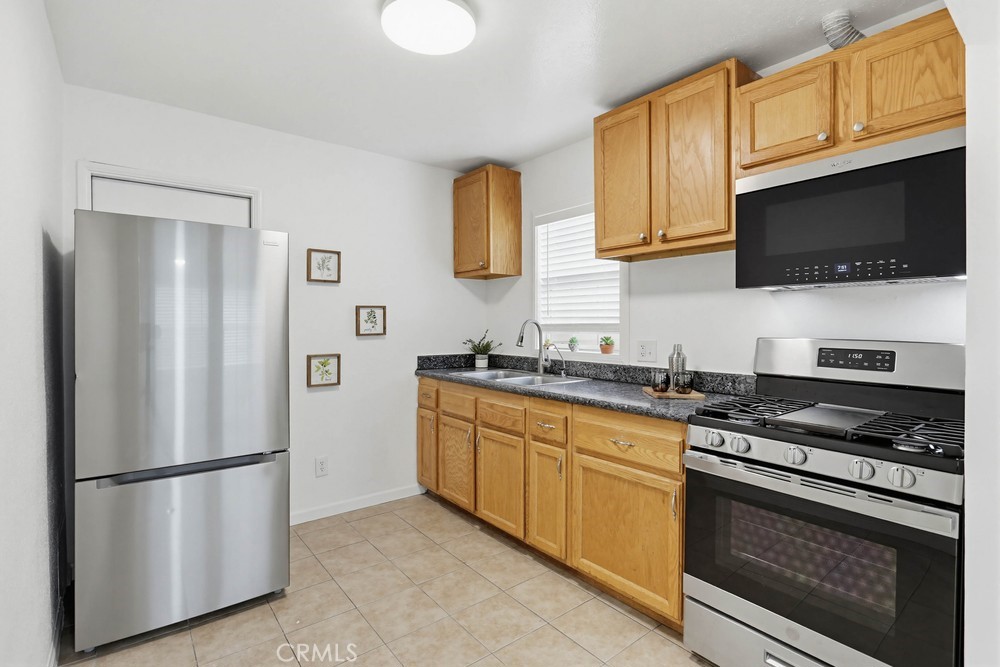 1104 Williamson Avenue Fullerton, CA 92833 - Photo 6 of 19 a kitchen with stainless steel appliances granite countertop a refrigerator stove a sink dishwasher and microwave with wooden floor