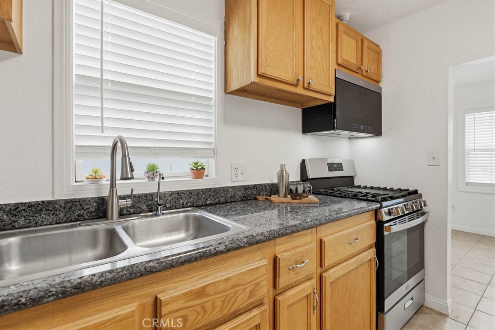 1104 Williamson Avenue Fullerton, CA 92833 - Photo 8 of 19 a kitchen with granite countertop a sink a stove and cabinets