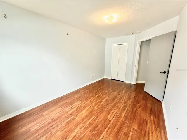 a view of empty room with wooden floor