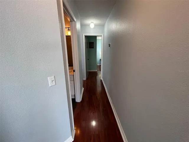 a view of a hallway with wooden floor