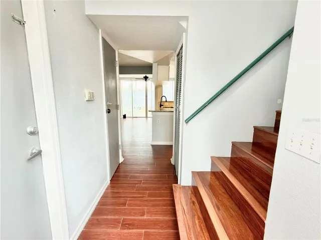 a view of a hallway with wooden floor and stairs