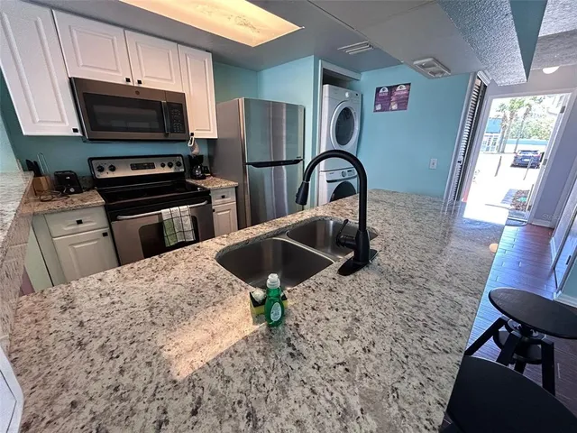 a kitchen with stainless steel appliances kitchen island granite countertop a stove a sink and a microwave