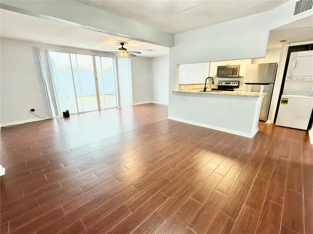a view of a kitchen with wooden floor and electronic appliances