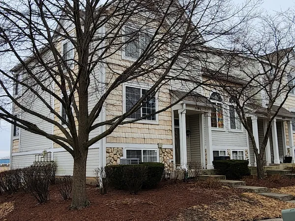 a front view of a house with a tree