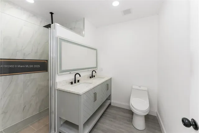 a bathroom with a sink toilet and mirror