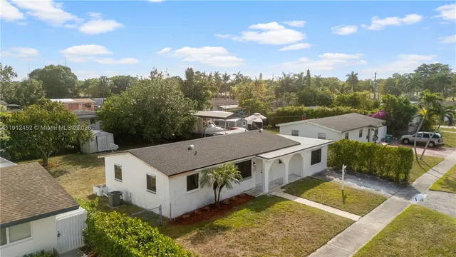 a view of a big house with a big yard and large trees