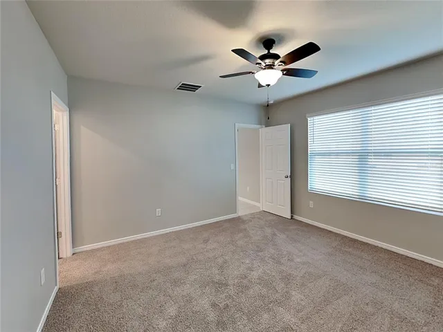 a view of an empty room with a ceiling fan