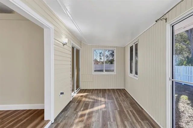 a view of a room with wooden floor and windows
