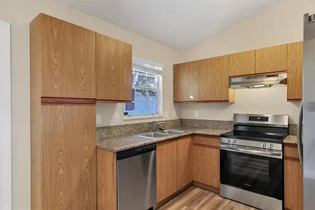 a kitchen with stainless steel appliances granite countertop a stove a refrigerator and a microwave