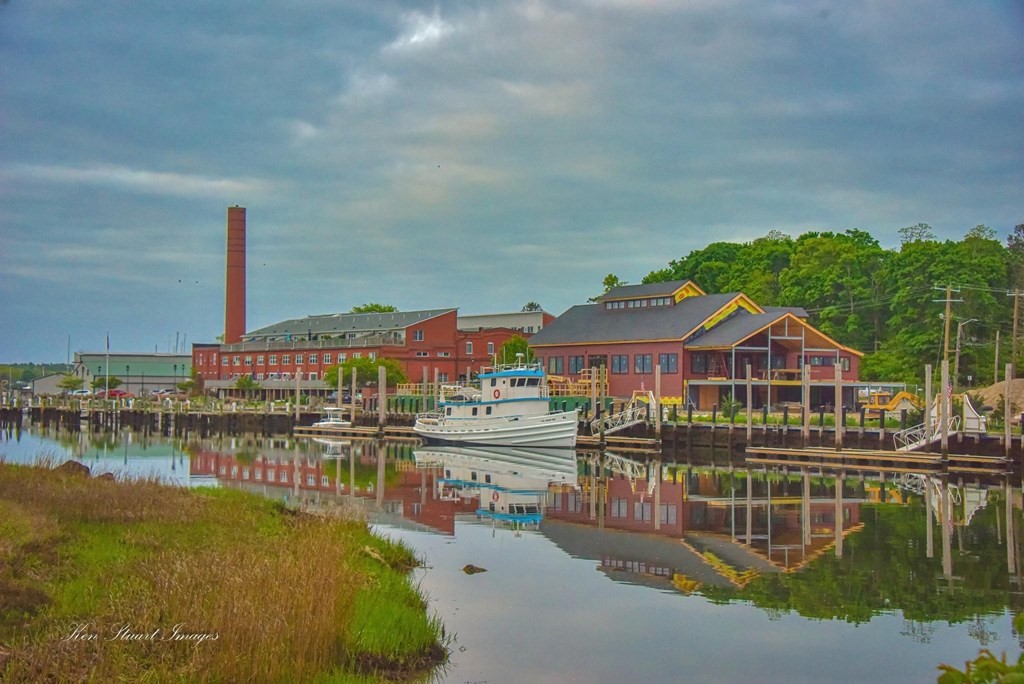 a view of a house with wooden deck and a lake view