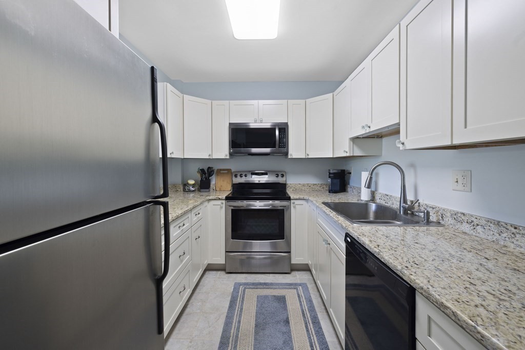 45 Main Street, Unit 111 Wareham, MA 02571 - Photo 8 of 20 a kitchen with granite countertop a refrigerator stove and sink