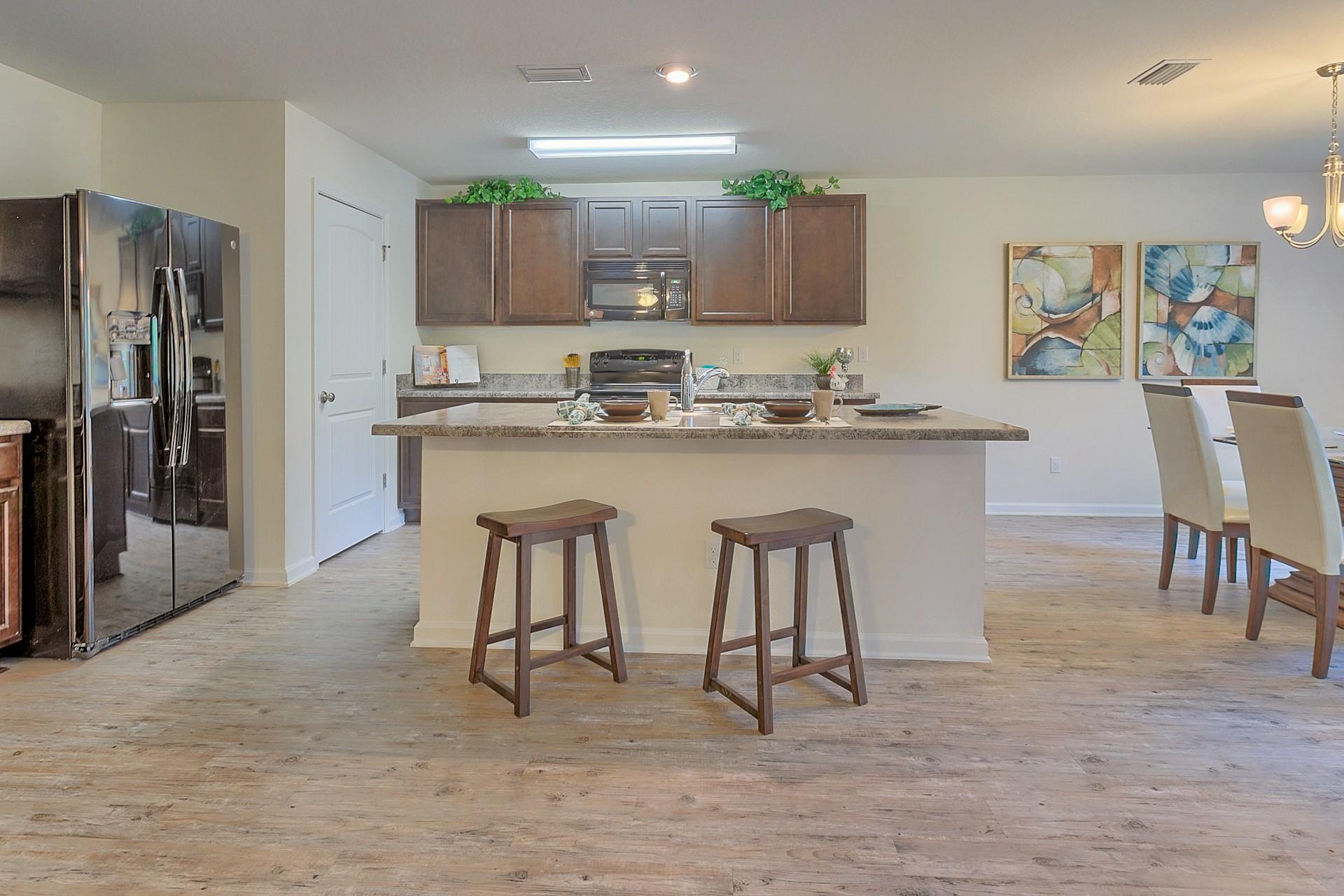 334 Merlin Court Crestview, FL 32539 - Photo 1 of 19 a kitchen with refrigerator and chairs