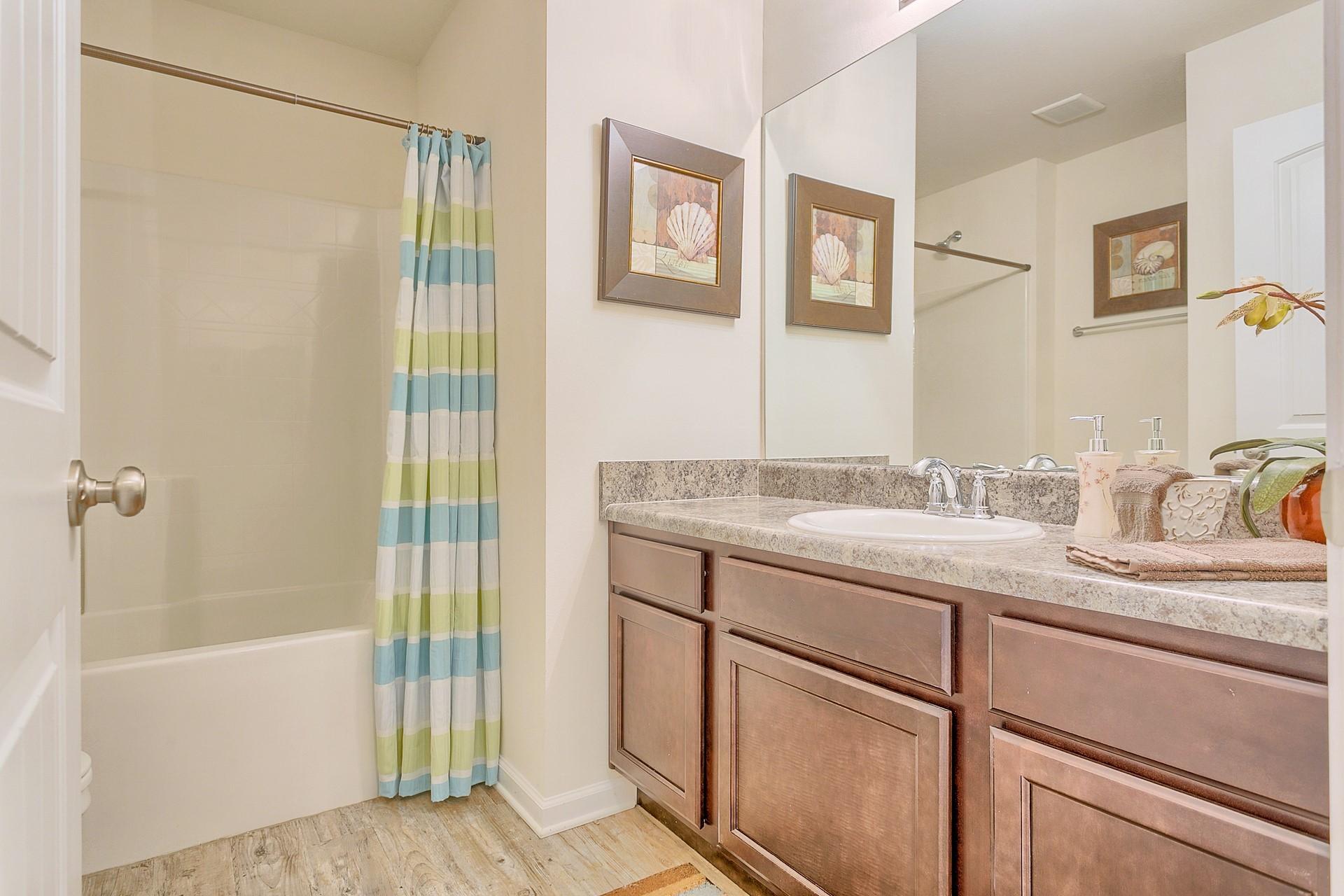 334 Merlin Court Crestview, FL 32539 - Photo 14 of 19 a bathroom with a granite countertop sink mirror bathtub and shower