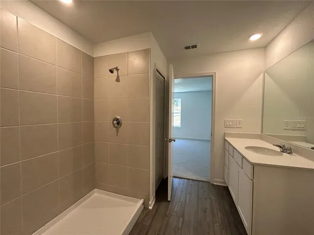 a bathroom with a sink a toilet a mirror and shower