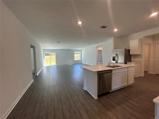 a kitchen with wooden floors and white walls