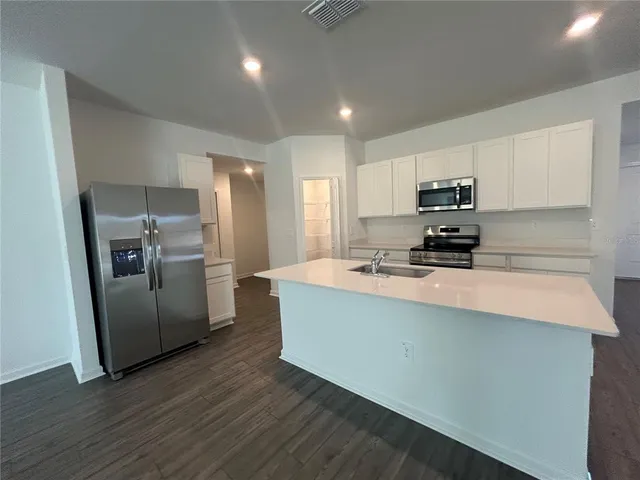 a kitchen with stainless steel appliances a refrigerator sink and microwave