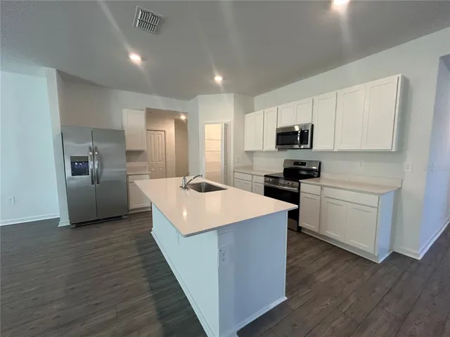 a kitchen with white cabinets and stainless steel appliances