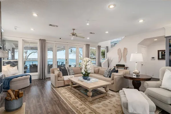 a living room with furniture large window and wooden floor