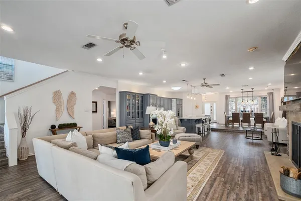 a living room with furniture kitchen view and a wooden floor