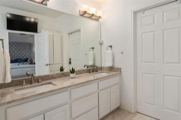 a bathroom with a granite countertop double sink and a mirror
