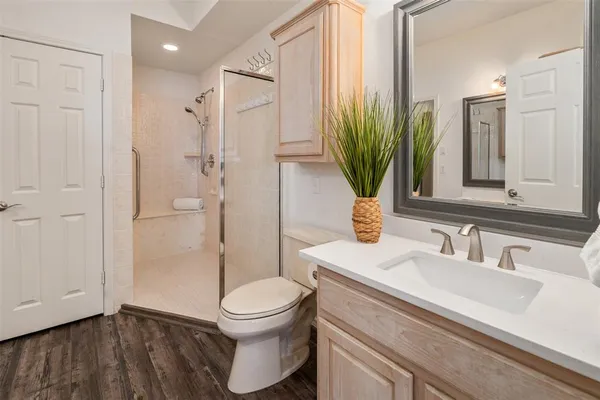 a bathroom with a sink a toilet and shower