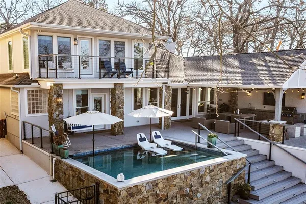 a view of a house with pool and chairs