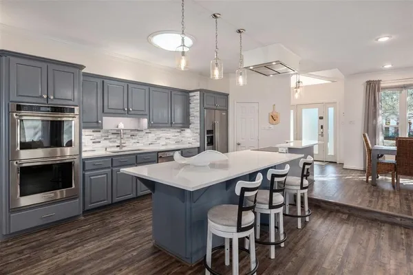 a kitchen with kitchen island a wooden floor and white cabinets