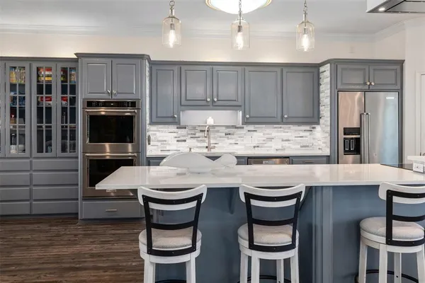 a kitchen with a table chairs refrigerator and cabinets