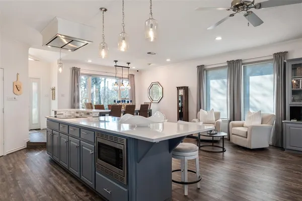 a large kitchen with a table chairs stove and wooden floor