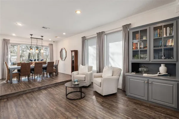 a living room with furniture a window and a dining table with wooden floor