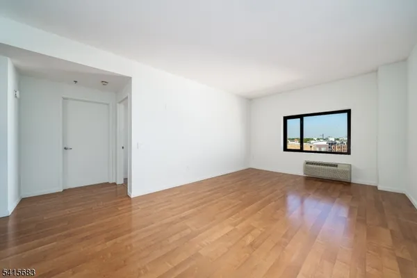 a view of a livingroom with wooden floor and a ceiling fan