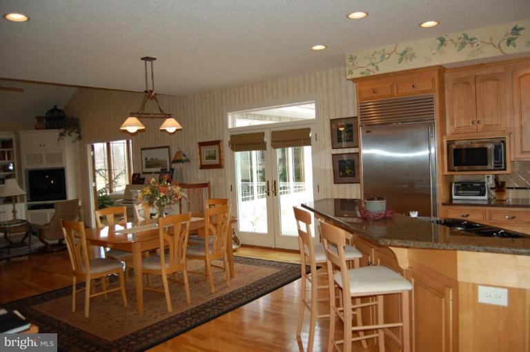 1133 Ragged Edge Road Chambersburg, PA 17202 - Photo 19 of 30 a kitchen with stainless steel appliances granite countertop a sink a stove a dining table and chairs