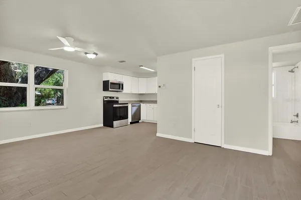 an empty room with windows and fireplace
