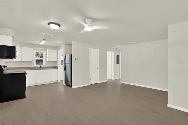 a view of a kitchen with a sink and dishwasher a refrigerator with white cabinets