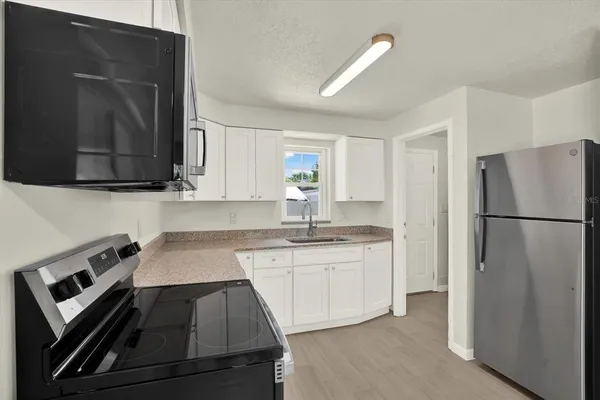 a kitchen with a sink stove and refrigerator
