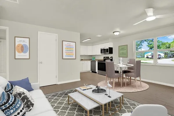 a living room with furniture and a dining table with kitchen view