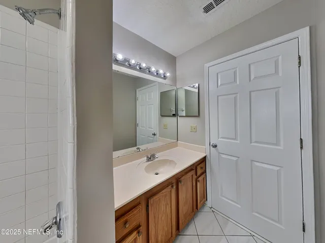 a bathroom with a sink a shower and a mirror