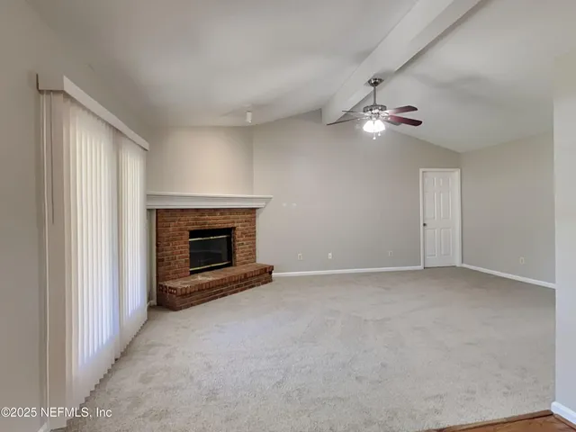 a view of empty room with a fireplace and fan