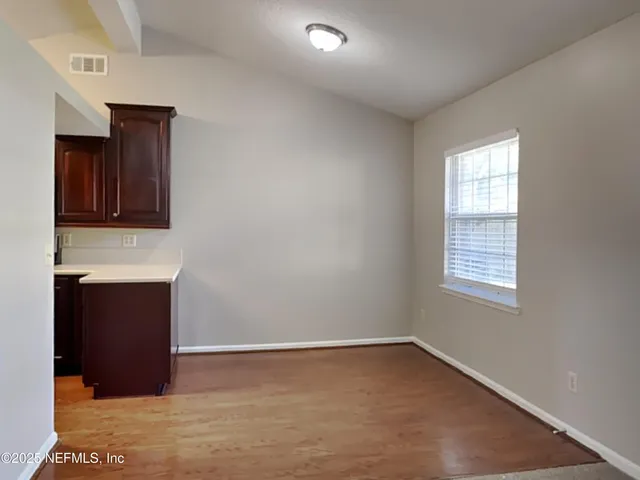a view of an empty room with closet and a window