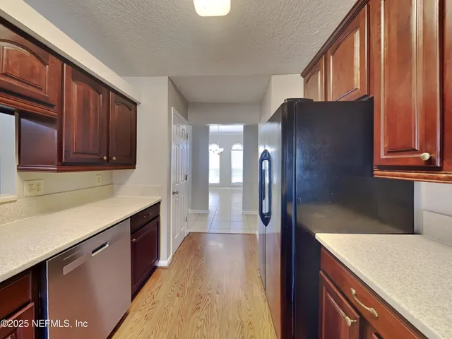a kitchen with stainless steel appliances granite countertop a refrigerator and a sink