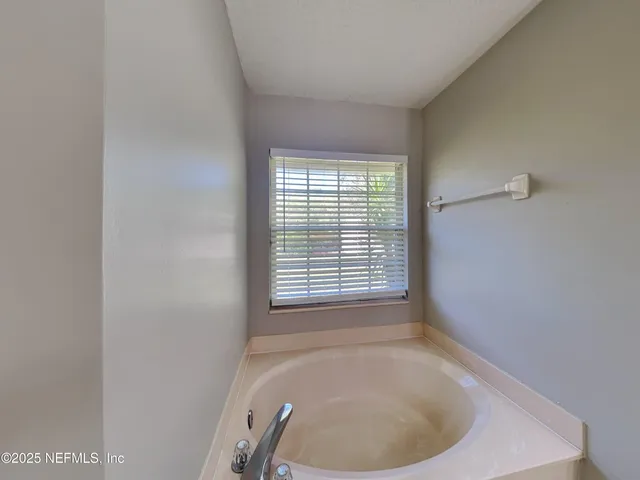 a bathroom with a bathtub and window