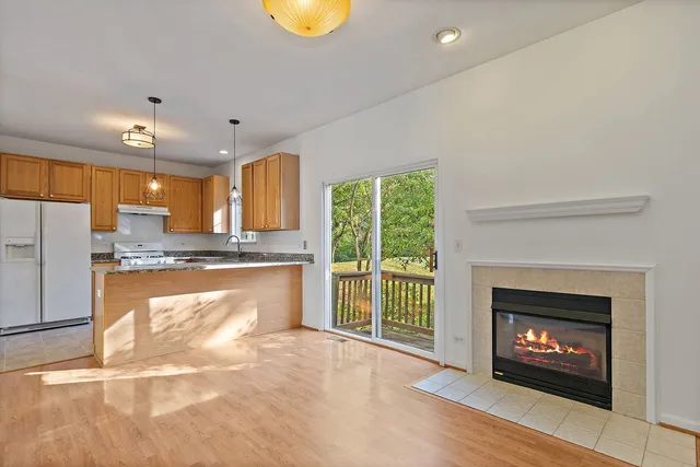 a open kitchen with granite countertop a stove top oven a sink and a wooden floor