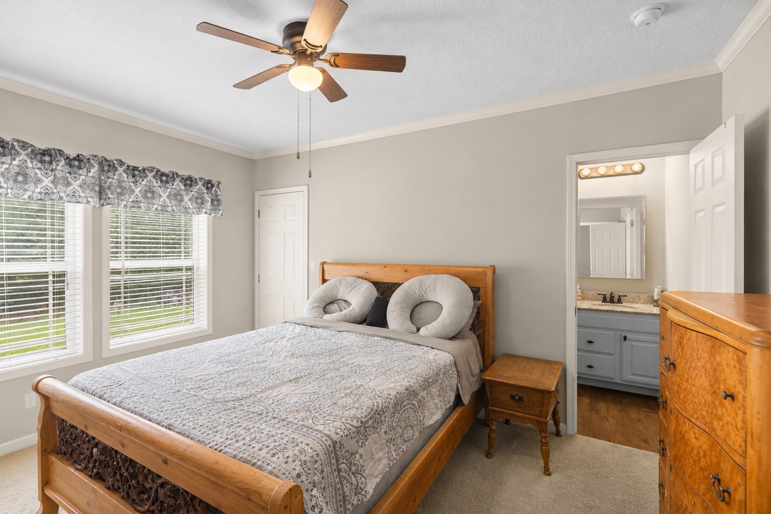 1800 2110th Road Hugo, OK 74743 - Photo 19 of 27 Two windows featuring blinds, wood-finish ceiling fan with integrated lighting, and crown molding